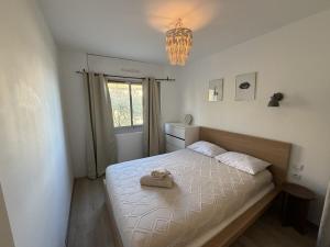 a bedroom with a bed with a towel on it at La Parenthèse Mézoise – Port plage à pied in Mèze