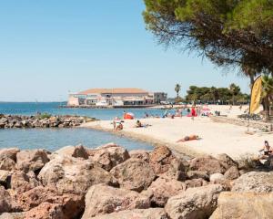 a group of people on a beach with rocks at La Parenthèse Mézoise – Port plage à pied in Mèze