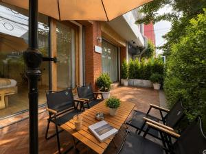 a patio with a table and chairs under an umbrella at Common Living Iconsiam in Bangkok