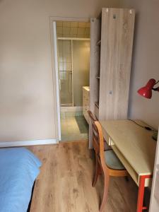 a room with a desk and a table and a bedroom at La Petite Pierre d'Octave Nr 1 in Saint Laurent Nouan