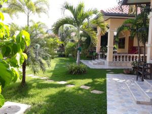 a yard with palm trees and a house at Stella Resort in Sam Roi Yot