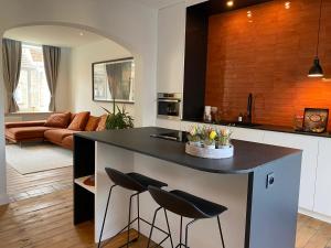 a kitchen with a island with two stools at Studio Mad Grace in Diksmuide