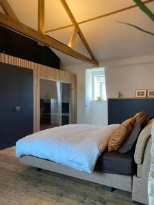 a bedroom with a large bed and a couch at Studio Mad Grace in Diksmuide