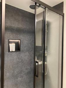 a shower with a glass door in a bathroom at Studio Mad Grace in Diksmuide