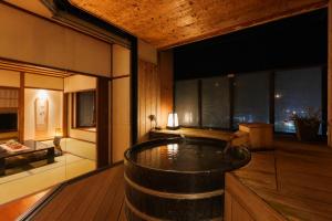 a room with a bath tub in the middle of a room at Tendo Onsen TAKINOYU in Tendo +86 photos