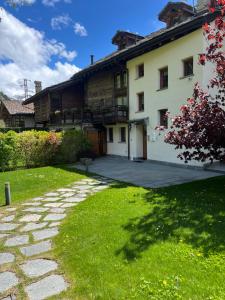 a house with a stone pathway in front of a yard at Residenza Loo Bach n 8 in Gressoney-Saint-Jean
