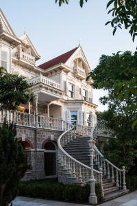 an old house with a staircase in front of it at Princes' Palace Resort, Buyukada - Member of The Leading Hotels of the World in Adalar