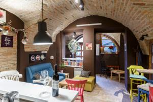 a restaurant with colorful chairs and a table with a bottle of wine at Maksimilian Osijek in Osijek