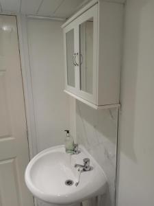 a bathroom with a white sink and a cabinet at Shetcliffe Lodge in Dudley Hill +19 photos