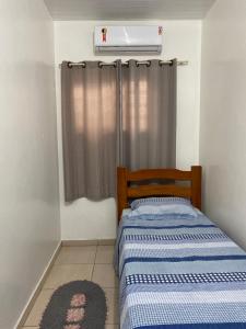 a small bedroom with a bed and a air conditioner at Hotel Maria in Marabá