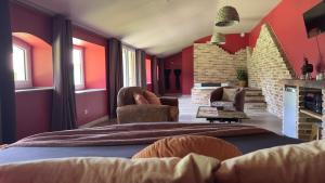 a bedroom with red walls and a bed and chairs at chambre INNAMORATO avec jacuzzi lit rond et jardin avec piscine in Saint-Martial-sur-Né