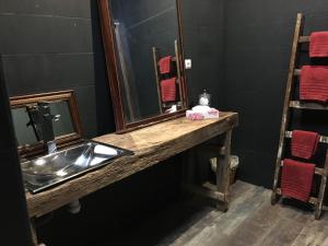 a bathroom with a sink and a mirror at chambre INNAMORATO avec jacuzzi lit rond et jardin avec piscine in Saint-Martial-sur-Né