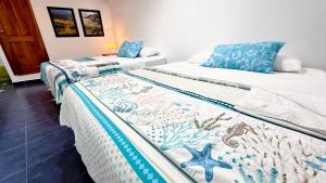 two beds in a room with blue and white sheets at Galapagos Family Vacation 3 bedrooms 7 guests Centrally located and ocean view in Puerto Ayora