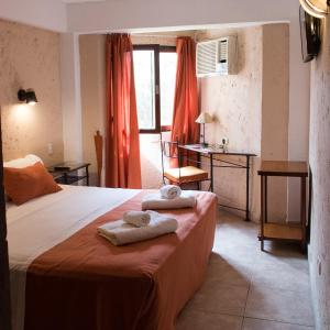 a bedroom with a bed with towels on it at Hotel Samka in Salta