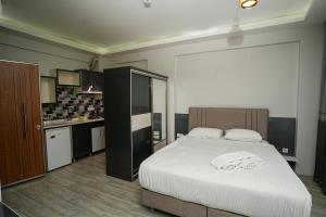 a bedroom with a large bed and a kitchen at Tk Residence in İzmir