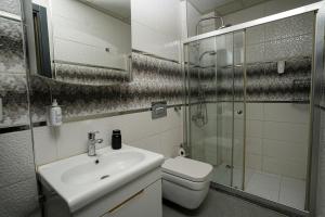 a bathroom with a sink and a toilet and a shower at Tk Residence in İzmir