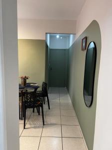 a dining room with a table and a mirror at Aconchegante Apartamento in Lavras