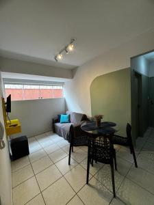 a living room with a table and a couch at Aconchegante Apartamento in Lavras
