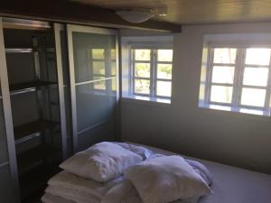 a bedroom with two pillows on a bed with windows at Det Bette Hus in Fladbjerg