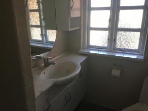 a white bathroom with a sink and a window at Det Bette Hus in Fladbjerg +9 photos