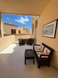 a living room with a couch and a table on a balcony at Yucca Park ApartHotel in Adeje