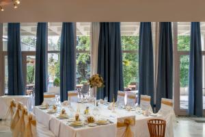 a table with white table cloths and chairs and windows at Hotel Belvedere in Cluj-Napoca +38 photos