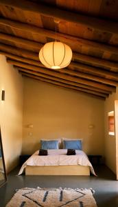 a bedroom with a bed with a wooden ceiling at Helder Farm Studios in São Teotónio
