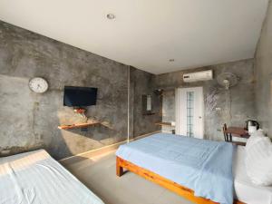 a bedroom with a bed and a tv on a wall at Dungkaew lakeview resort in Amphoe Ban Dung
