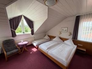 a bedroom with a bed and a chair in a attic at Hotel am Neckar in Nürtingen