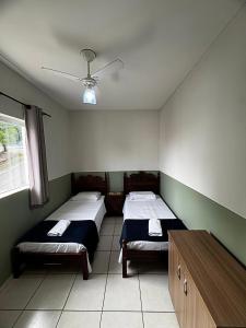 a room with two beds and a table in it at Aconchegante Apartamento in Lavras