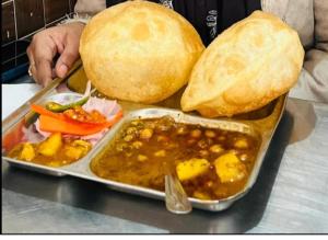 a tray of food on a table with a plate of food at Aastha view inn in Amritsar