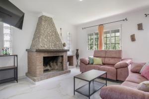 a living room with a fireplace and a couch at Casa de Piedra in El Cañal