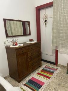 a bathroom with a wooden dresser and a mirror at Quartos em Tiradentes MG - A Casa Sarará in Tiradentes +93 photos