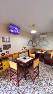 a dining room with a table and chairs and a tv at Pousada Morena Raiz in Ubatuba