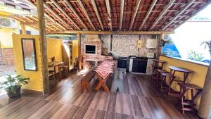 a room with a table and chairs and a kitchen at Pousada Morena Raiz in Ubatuba
