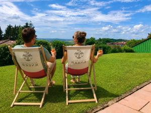 a man and woman sitting in chairs on the grass at Apartment Kneer - Panoramic View & Private Garden near Black Forest & Lake Constance in Donaueschingen