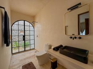 ein Badezimmer mit Toilette und Spiegel in der Unterkunft Casa Bacah in Bacalar + 6 Fotos