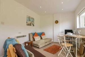 a living room with a couch and a table at Bungalow - Sleeps 2 - Parking in Newquay