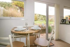 a dining room with a table and chairs and a window at Bungalow - Sleeps 2 - Parking in Newquay