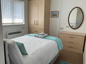 a bedroom with a large bed and a mirror at Bungalow - Sleeps 2 - Parking in Newquay