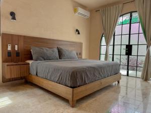 ein Schlafzimmer mit einem Bett und einem großen Fenster in der Unterkunft Casa Bacah in Bacalar