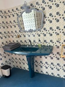 a bathroom with a blue sink and a mirror at Angel du Mont in Pontorson