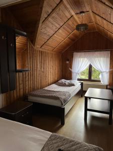 a bedroom with two beds in a wooden cabin at Zacisze Zbiczno in Zbiczno