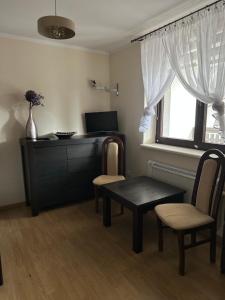 a living room with a table and chairs and a window at Zacisze Zbiczno in Zbiczno