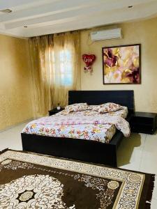 a bedroom with a bed and two rugs in it at Le palmier in Mezraya