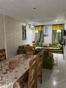 a living room with a table and a couch at Le palmier in Mezraya