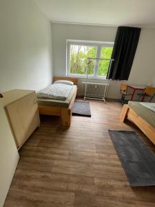 a room with two beds and a window at GM Zimmervermietung in Hamburg