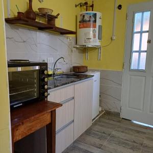 a kitchen with a microwave and a stove top oven at Génesis in Merlo