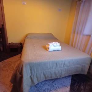 a bed with two towels and a teddy bear on it at Génesis in Merlo