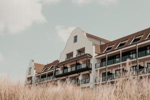 an external view of a building with tall grass at Hotel de Blanke Top in Cadzand-Bad